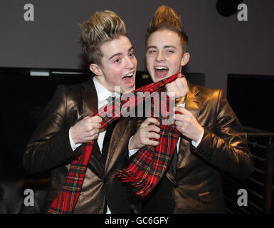 John et Edward, alias Jedward, anciens concurrents de X Factor posent pour les photographes avec un foulard tartan à la City Nightclub de Falkirk lors d'une visite en Écosse pour deux concerts. Banque D'Images