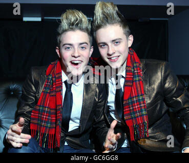 John et Edward, alias Jedward, anciens concurrents de X Factor posent pour les photographes avec un foulard tartan à la City Nightclub de Falkirk lors d'une visite en Écosse pour deux concerts. Banque D'Images