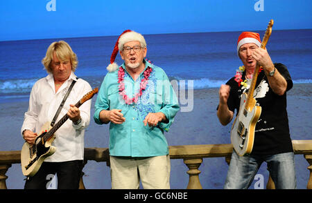 (De gauche à droite) Rick Parfitt, Rolf Harris et Wayne Morris filme la vidéo pour leur nouveau single Christmas in the Sun, aux Shepperton Studios de Twickenham. Banque D'Images