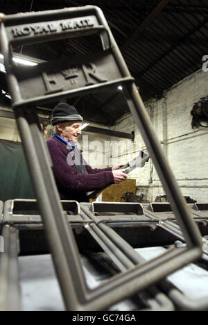 John Cooper, 69 ans, qui a fait des boîtes aux lettres depuis son âge de 15 ans, avec les panneaux avant des boîtes de lampes Royal Mail à Machan Engineering à Denny. Machans est la seule entreprise au Royaume-Uni à fabriquer la boîte postale du Royal Mail. Banque D'Images