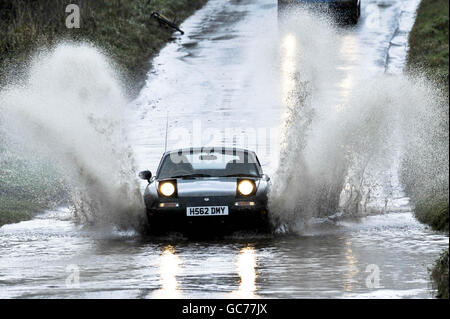 Une voiture traverse une route inondée dans le Somerset après deux jours de forte pluie. Les routes du comté ont une eau stagnante étendue et des zones inondées localisées après ce qui a été l'un des Novembers les plus humides jamais enregistré. Banque D'Images