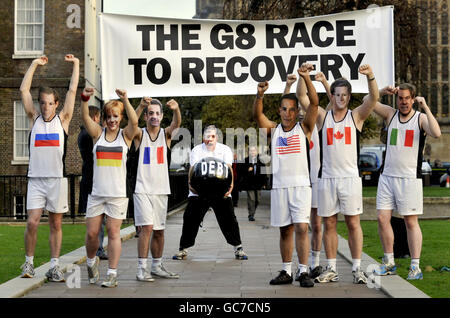 Les gens qui portent le masque des dirigeants du G8 prétendent faire la course alors que le concurrent masqué de Gordon Brown est accablé de dette dans une séance photo organisée par le parti conservateur, en dehors des chambres du Parlement, pour suggérer que la Grande-Bretagne perd la course pour se remettre de la crise économique mondiale. Banque D'Images