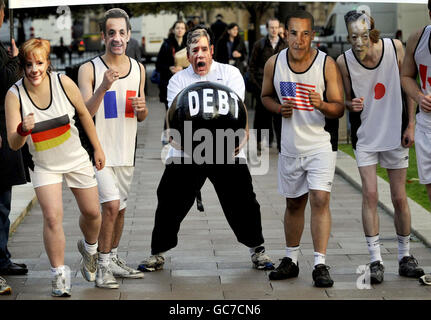 Les gens qui portent le masque des dirigeants du G8 prétendent faire la course alors que le concurrent masqué de Gordon Brown est accablé de dette dans une séance photo organisée par le parti conservateur, en dehors des chambres du Parlement, pour suggérer que la Grande-Bretagne perd la course pour se remettre de la crise économique mondiale. Banque D'Images