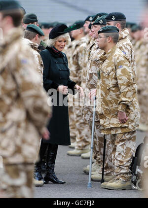 Lance Caporal Tyler Christopher du 4e Bataillon les fusils se dresse alors que la duchesse de Cornwall se déplace vers lui alors qu'elle a présenté des médailles de campagne aux soldats qui se sont battus en Afghanistan lors d'une visite au camp de Bulford, à Salisbury, dans le Wiltshire. Banque D'Images