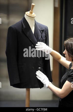 Un membre du personnel de Bonhams ajuste une veste croisée, que l'étoile aurait portée dans le film « action dans le Nord », lors d'une vente de souvenirs de divertissement photo Bonhams à Londres. Banque D'Images