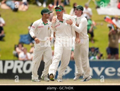 Alastair Cook, en Angleterre, est pris par le capitaine d'Afrique du Sud Graeme Smith (au centre) lors du premier test au SuperSport Park, Centurion, en Afrique du Sud. Banque D'Images