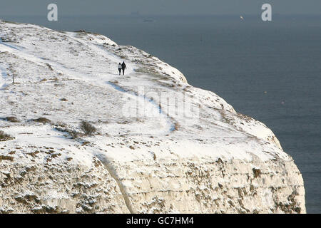 Un couple fait une promenade le long des falaises blanches de Douvres, dans le Kent, pendant que le temps froid continue. Banque D'Images