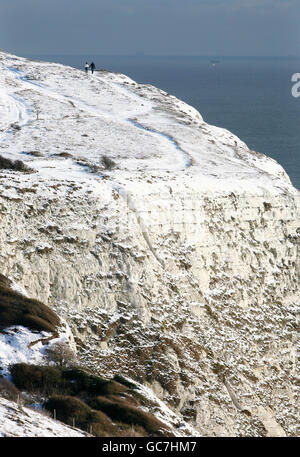 Un couple fait une promenade le long des falaises blanches de Douvres, dans le Kent, pendant que le temps froid continue. Banque D'Images