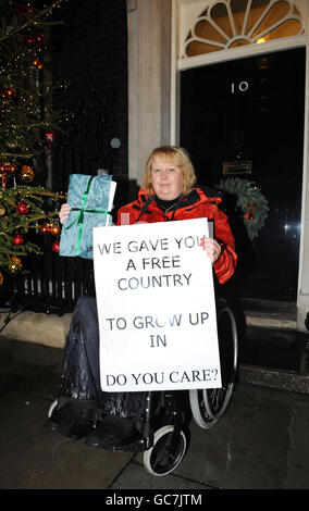 Maria Hobbs, une utilisatrice de fauteuil roulant de Bridgwater, Somerset, à l'extérieur du 10 Downing Street, où elle s'est jointe à d'autres pour présenter une pétition exhortant le gouvernement à ne pas réduire le nombre de gardes travaillant dans des logements protégés. Banque D'Images