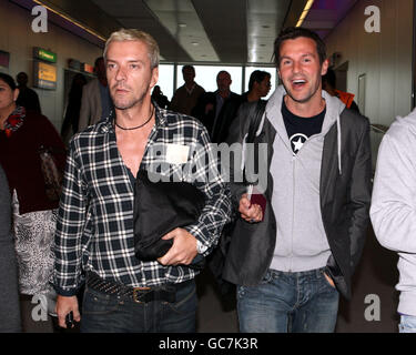 Je suis une célébrité Je suis sorti d'ici les concurrents Colin McAllister et Justin Ryan reviennent au terminal 3 de l'aéroport de Heathrow, Middlesex. Banque D'Images