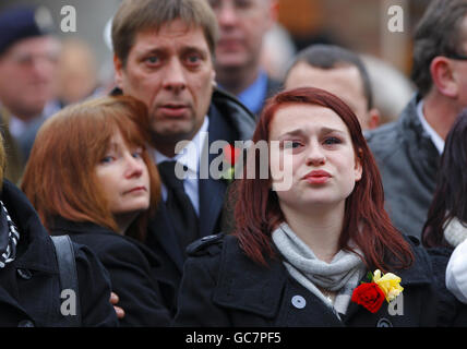 Sian Goodenough, la fiancée du caporal Adam Drane attend avec ses parents des et Jackie (derrière) son cercueil pour traverser Wootton Bassett dans le Wiltshire. Banque D'Images