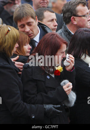 Sian Goodenough, la fiancée du caporal Adam Drane attend avec ses parents des et Jackie (derrière) son cercueil pour traverser Wootton Bassett dans le Wiltshire. Banque D'Images