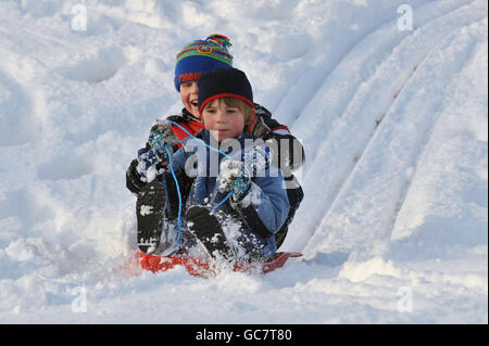 John et Harry, enfants de cinq ans, se mettent à bord d'un traîneau à Ingatestone, dans l'Essex, après une chute de neige de nuit. Banque D'Images