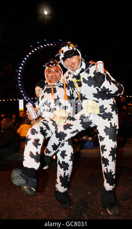 Fêtards, de gauche à droite, Brian Knowlayn et Nick Shelley, tous deux des douaniers de Douvres, Kent, vêtus de vaches pour marquer l'année chinoise de la vache, attendent une exposition pyrotechnique sur la South Bank de Londres, y compris le London Eye, marquant les célébrations du nouvel an 2010 dans la capitale. Banque D'Images