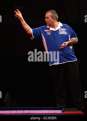 Phil Taylor en action contre Adrian Lewis lors du Championnat du monde des fléchettes Ladbrokes.com à Alexandra Palace, Londres. Banque D'Images