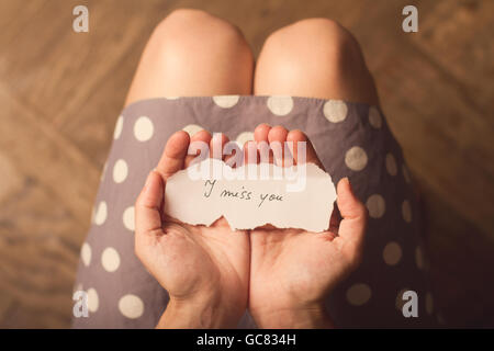 Top View of woman in dress holding avec un message papier avec le texte I miss you Banque D'Images