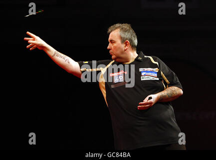 Phil Taylor en action contre Colin Monk pendant le Championnat du monde des fléchettes Ladbrokes.com à l'Alexandra Palace, Londres. Banque D'Images