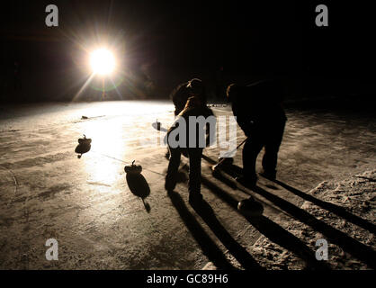 Un match de rebond entre le port de Mentenith et les clubs de curling de Strathendrick les contes se déroulent sous la lumière des projecteurs la nuit sur le lac gelé de Mentenith, alors que les températures continuaient de chuter dans toute la Grande-Bretagne. Un tournoi de curling en plein air a aujourd'hui été mis hors service parce que les services d'urgence ont déclaré qu'ils ne pouvaient pas garantir la sécurité des joueurs. Le Grand Match, prévu pour la semaine prochaine, aurait été le premier événement de ce genre depuis plus de 30 ans. Le Bonspiel aurait impliqué 2,000 concurrents de toute l'Écosse. Banque D'Images