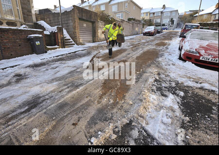 Les travailleurs jettent des grains frais sur le chemin Kensington Park à Brislington, Bristol, alors que Bristol Water tentait de réparer une conduite d'eau en rafale qui a inondé la route. Banque D'Images