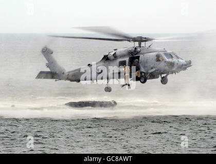 US Navy SEALS goutte dans l'océan d'un HH-60H Seahawk hélicoptère pendant une simulation d'agression de plage de l'entraînement à la force expéditionnaire conjointe Base Little Creek le 17 juillet 2010 à Fort Story, Virginie. Banque D'Images
