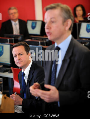 Le chef du Parti conservateur David Cameron (à gauche) écoute le Secrétaire d'État adjoint à l'enfance, à l'école et à la famille, Michael Gove, qui parle à la Walworth Academy de Londres de la politique d'éducation proposée par le parti. Banque D'Images