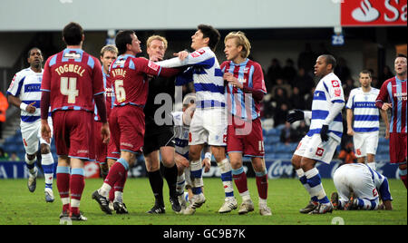 Le Cliff Byrne de Scunthorpe United échange des mots avec Grant McCann (au centre) de QPR alors que les esprits s'évertuent entre les deux parties lors du match de championnat Coca-Cola à Loftus Road, Londres. Banque D'Images