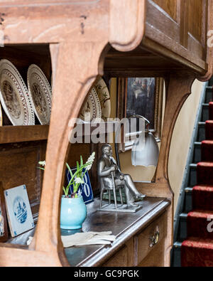 Lampe Vintage et statue avec assiettes décoratives sur meubles anciens en cabinet à Nottinghill couloir, Londres, Royaume-Uni Banque D'Images