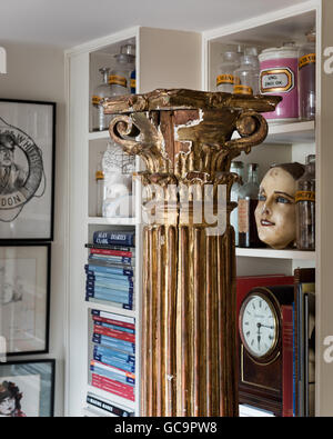 Pots d'apothicaire et de livres sur des étagères avec un pilier en appartement à Londres rempli de bibelots Banque D'Images