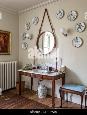 Fornasetti plaques arlequin sur mur autour d'un miroir moderne de conran. La coiffeuse est recouvert de marbre réalisés par Nick Coryndon Banque D'Images