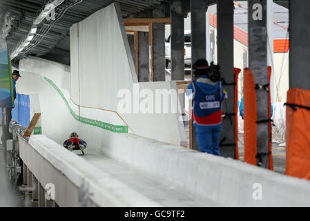 Adam Rosen, de la Grande-Bretagne, passe le dernier coin en passant devant le nouveau tableau de bord de sécurité et les poteaux rembourrés sur le site d'un accident d'antan lors d'une séance de formation de luge au Whistler Sliding Centre, Whistler, Canada. Banque D'Images