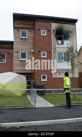 Image du fichier, datée du 17/07/2009. Un policier se tient à l'extérieur d'une maison dans la région d'Openshaw, à Manchester, où trois frères et sœurs ont été tués dans un incendie. Banque D'Images