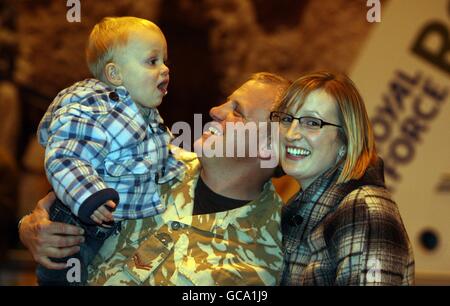 Tim Travis, du 27 Sqn RAF Regiment, est accueilli par sa femme, Chantelle, et son fils, Morgan, à son retour à la RAF Honington, Suffolk, après une visite de six mois en Afghanistan. Banque D'Images