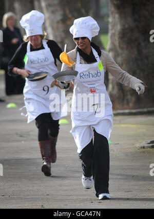 Reeta Chakrabarti de la BBC (à droite) et la baronne Miller de Chilthorne Domer participent à la course parlementaire annuelle de Pancake à Westminster, Londres, ainsi que d'autres journalistes, députés et membres de la Chambre des Lords, Recueillir de l'argent pour l'organisme de bienfaisance Rehab et sensibiliser les gens handicapés à son travail. Banque D'Images