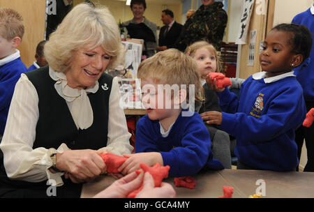 La duchesse de Cornwall fait des formes avec du plalene avec des jeunes de trois ans Jake Barr et Amanda Phiri à l'école Kiwi lors de sa visite au camp de Bulford à Salisbury, Wiltshire, où elle a rencontré des soldats et des familles du 4e Bataillon, les Rifles. Banque D'Images