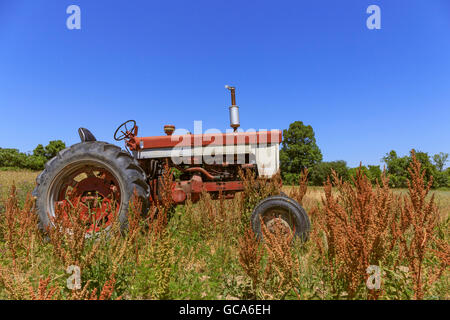 Un vieux millésime tracteur dans un champ dans la région des lacs Finger de l'Upstate, New York. Banque D'Images