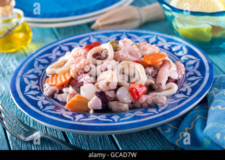 Une délicieuse salade de fruits de mer mixtes avec les poulpes, calmars, crevettes, oignons, poivron rouge, et la carotte. Banque D'Images