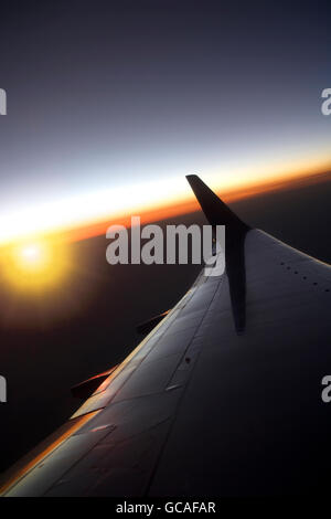 BOEING 737 700 BOUGIES SUR HORIZON COUCHER DU SOLEIL D'AILE Banque D'Images