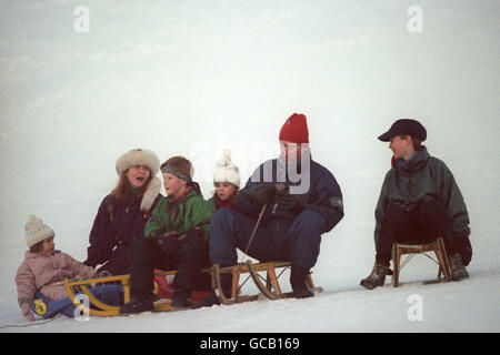 PRINCE DE GALLES ET BELLE-SŒUR, LA DUCHESSE D'YORK AVEC LEURS ENFANTS L-R PRINCESSE EUGÉNIE, PRINCE HARRY, PRINCESSE BEATRICE ET PRINCE WILLIAM LORS D'UNE COURSE ROYALE DE LUGE SUR LES PENTES DEVANT LEUR HÔTEL AU SWISS RESORT OF KLOSTERS. Banque D'Images