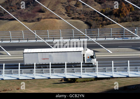 Chariot qui se déplace sur l'autoroute et un grand viaduc qui domine tout le paysage Banque D'Images