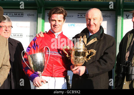 Le Capt Harry Wallace célèbre la victoire de la course de poursuite à l'agrafe de la coupe d'or de l'Atillery royale avec son père, le major Malcolm Wallace, qui a également remporté la coupe de l'Artillerie royale lors de la Journée de la coupe d'or de l'Artillerie royale à l'hippodrome de Sandown, à Surrey. Banque D'Images