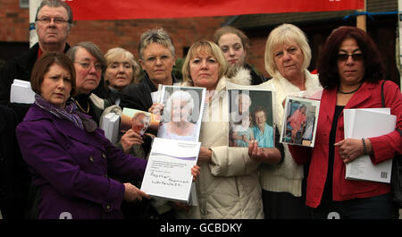 Les parents des patients impliqués dans le rapport tiennent des photos de leurs proches à l'extérieur de l'hôtel Moat House près de Stafford, après que Robert Francis QC a remis son rapport sur les échecs à l'hôpital Stafford. Banque D'Images