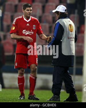 Football - UEFA Europa League - Round of 32 - second Leg - Unirea Urziceni / Liverpool - Stade Steaua.Le capitaine de Liverpool Steven Gerrard (à gauche) remet son brassard à un garçon de balle après le coup de sifflet final Banque D'Images