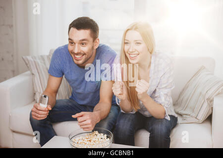 Smiling couple avec popcorn sports team cheering Banque D'Images