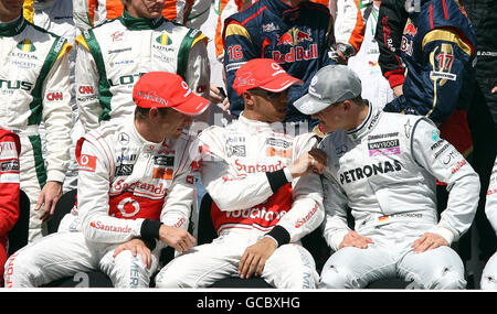 Lewis Hamilton et Jenson Button discutant avec Michael Schumacher lors de la photo annuelle de l'écurie avant le Grand Prix Gulf Air Bahrain au circuit international de Bahreïn à Sakhir, Bahreïn. Banque D'Images