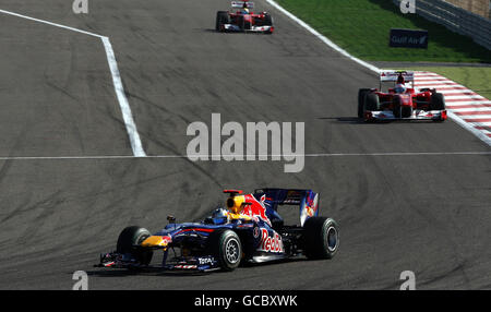 Sebastian Vettel de Redbull dirige les deux Ferrari sur les tours d'ouverture du Grand Prix Gulf Air Bahrain au circuit international de Bahreïn à Sakhir, Bahreïn. Banque D'Images