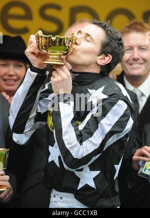 Courses hippiques - 2010 Cheltenham Festival - quatrième jour.Le jockey Paddy Brennan embrasse le Trophée de la coupe d'or après l'avoir remporté à bord du commandant impérial. Banque D'Images