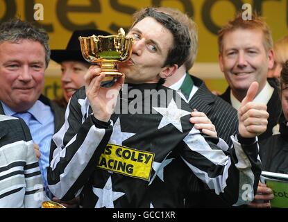 Le jockey Paddy Brennan embrasse le Trophée de la coupe d'or après avoir remporté le totesport Cheltenham Gold Cup commandant impérial. Banque D'Images