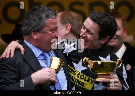 Le jockey Paddy Brennan (à droite) fête avec l'entraîneur Nigel Twiston-Davies après Le commandant impérial remporte la coupe d'or Totesport Cheltenham Banque D'Images