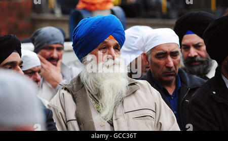 Les amateurs de deuil à l'extérieur du temple sikh à Huddersfield pendant le service funéraire du commerçant Gurmail Singh. Banque D'Images