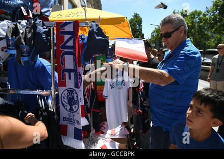 Paris, France. 09 juillet, 2016. Un homme regarde les produits de marchandises de l'équipe française lors d'une boutique de souvenirs à l'Avenue des Champs-Elysées à Paris, France, 09 juillet 2016. La France face au Portugal dans l'UEFA EURO 2016 football match final le 10 juillet 2016. Photo : Federico Gambarini/dpa/Alamy Live News Banque D'Images